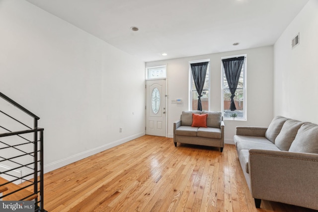 interior space featuring light wood-style flooring, stairway, visible vents, and baseboards