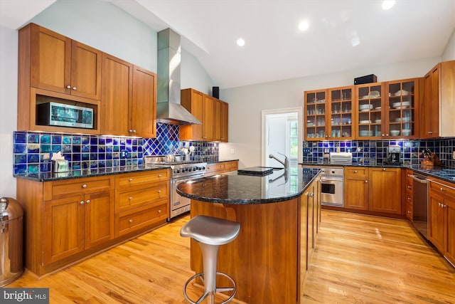 300 E Broad St, Falls Church, VA 22046 - kitchen with appliances with stainless steel finishes, wall chimney range hood, a center island, light wood-style flooring, and vaulted ceiling