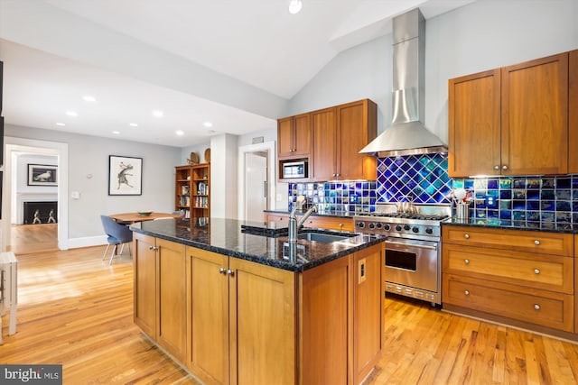 300 E Broad St, Falls Church, VA 22046 - kitchen with wall chimney exhaust hood, appliances with stainless steel finishes, light wood finished floors, brown cabinets, and an island with sink