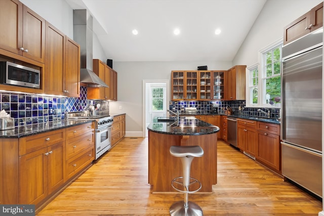 300 E Broad St, Falls Church, VA 22046 - kitchen featuring built in appliances, wall chimney exhaust hood, lofted ceiling, light wood finished floors, and a kitchen island with sink