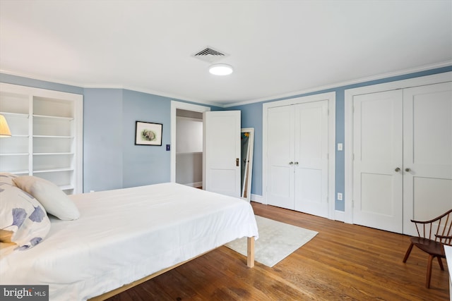 300 E Broad St, Falls Church, VA 22046 - bedroom featuring two closets, wood finished floors, and ornamental molding