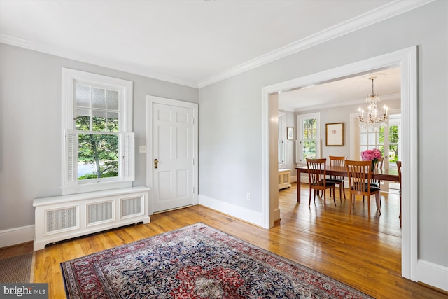 300 E Broad St, Falls Church, VA 22046 - entrance foyer featuring radiator, wood finished floors, ornamental molding, and a chandelier