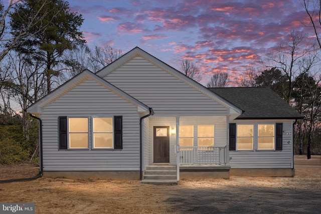 view of front of property featuring a porch and roof with shingles