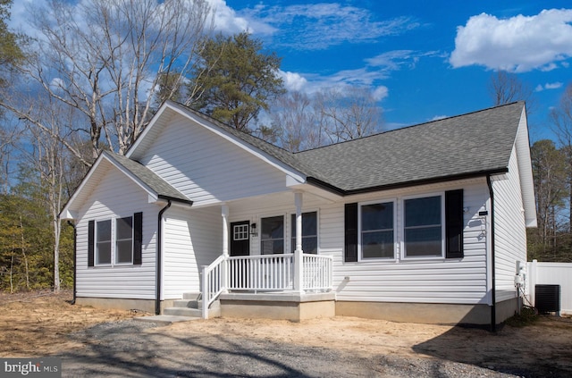 view of front of property with central AC unit, covered porch, and roof with shingles