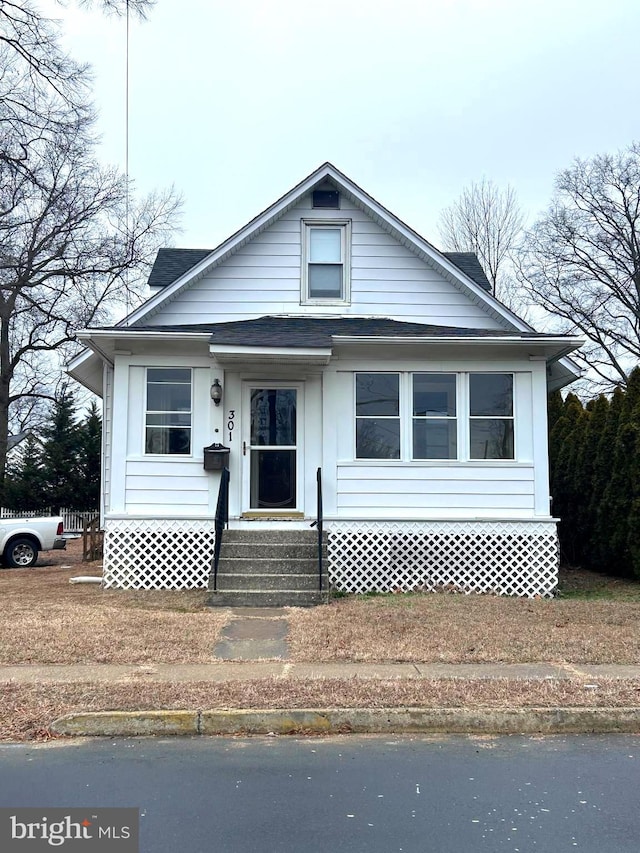 bungalow-style house with entry steps and roof with shingles