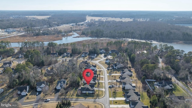 birds eye view of property with a water view and a wooded view