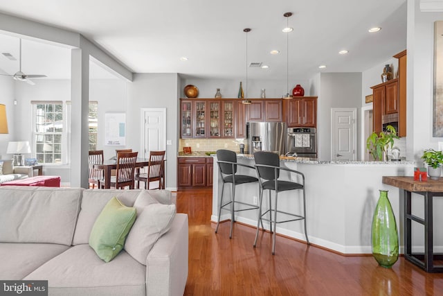 living room with light wood-style flooring, ceiling fan, and recessed lighting