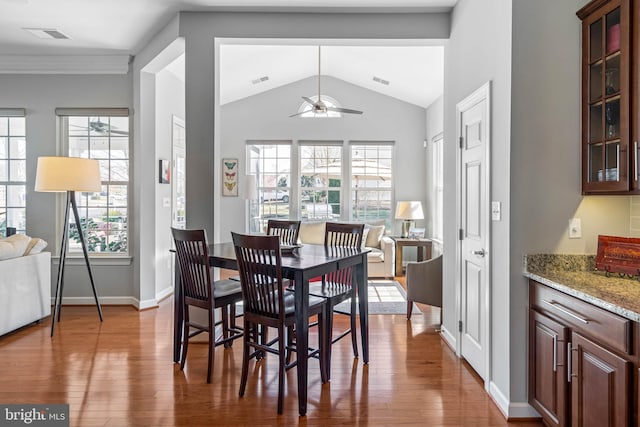 dining space with lofted ceiling, ceiling fan, baseboards, and wood finished floors