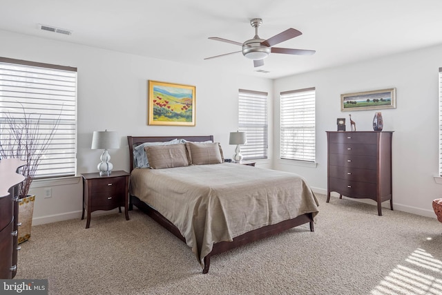 bedroom featuring baseboards, ceiling fan, visible vents, and light colored carpet