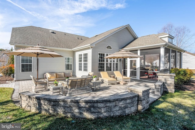 rear view of house featuring a sunroom, roof with shingles, a patio, and an outdoor hangout area