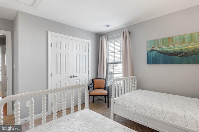 carpeted bedroom with a closet and visible vents