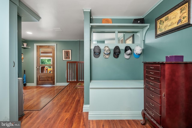 interior space featuring ornamental molding, baseboards, and wood finished floors