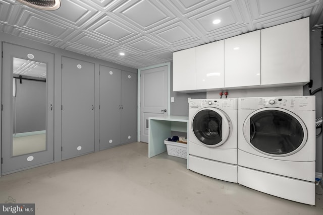 washroom featuring an ornate ceiling, cabinet space, and washing machine and dryer