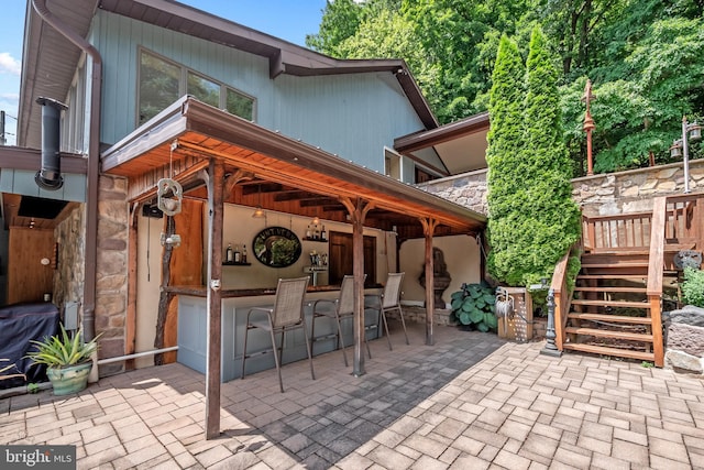 view of patio with stairs and exterior bar