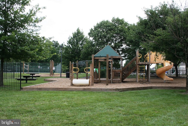 community playground featuring a lawn and fence