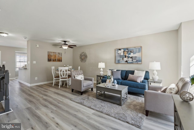 living room with ceiling fan, wood finished floors, and baseboards