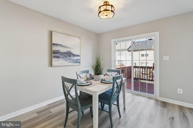 dining space with light wood-style floors and baseboards