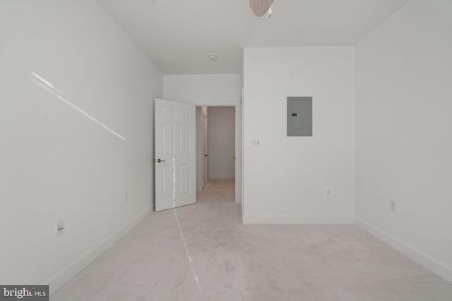 unfurnished bedroom featuring baseboards, electric panel, and light colored carpet