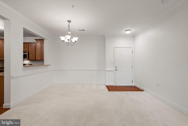 interior space with a notable chandelier, carpet floors, visible vents, baseboards, and crown molding