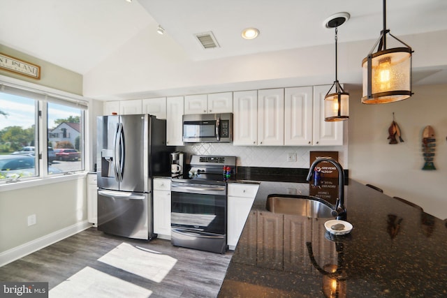 kitchen with stainless steel appliances, a sink, visible vents, white cabinets, and pendant lighting