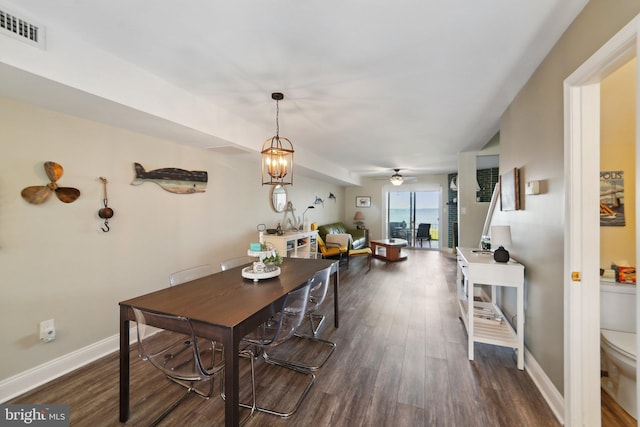 dining room featuring baseboards, visible vents, dark wood finished floors, and ceiling fan with notable chandelier