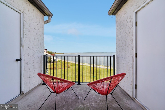 balcony with a water view and a view of the beach