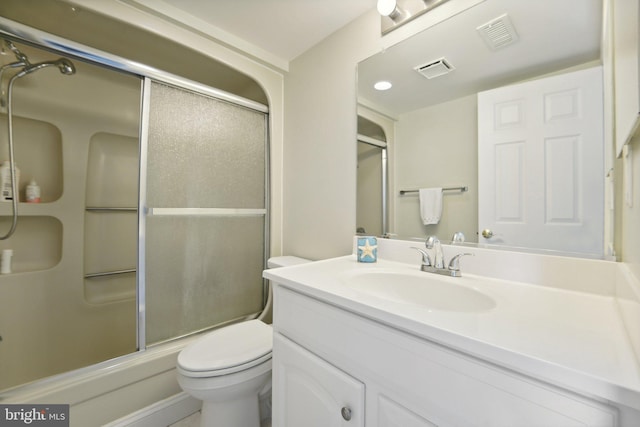 bathroom featuring toilet, a shower with door, visible vents, and vanity