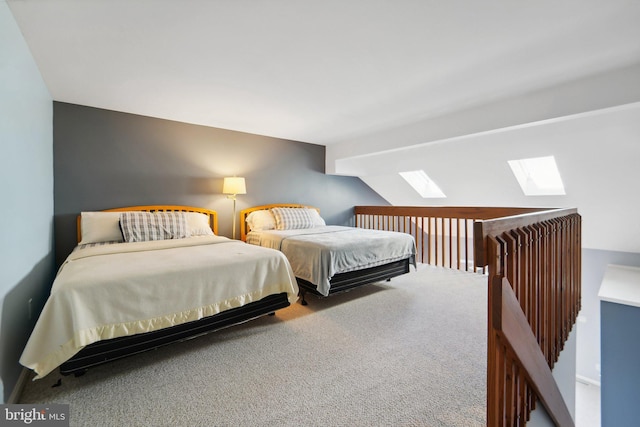 carpeted bedroom featuring lofted ceiling with skylight