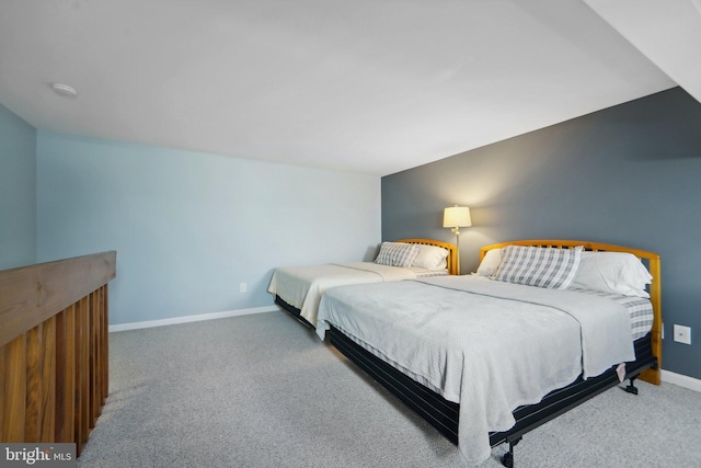 carpeted bedroom with lofted ceiling and baseboards