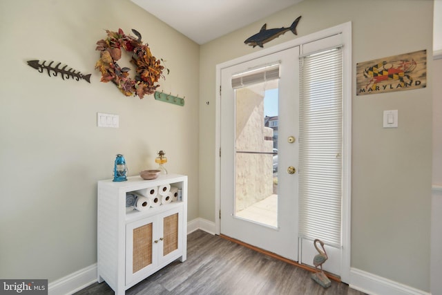 doorway featuring wood finished floors and baseboards