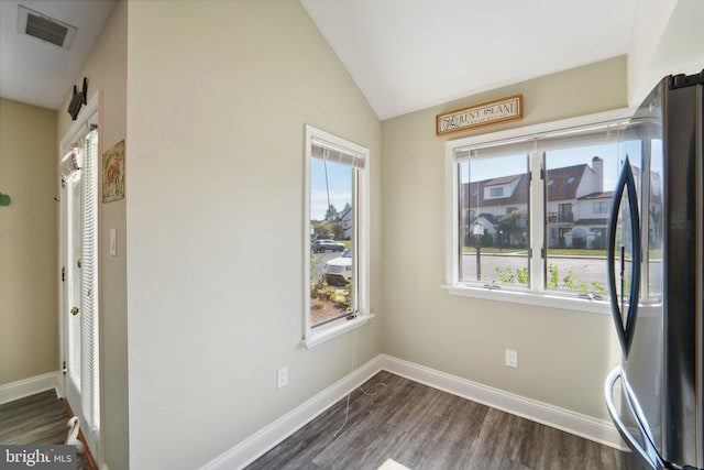 interior space featuring lofted ceiling, dark wood-style flooring, visible vents, and baseboards