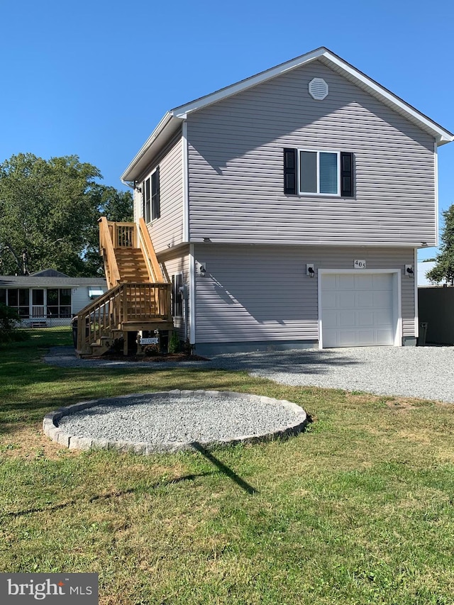 view of side of home with a garage, driveway, a yard, and stairway