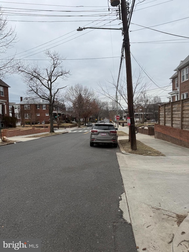 view of road with curbs, street lighting, traffic signs, and sidewalks