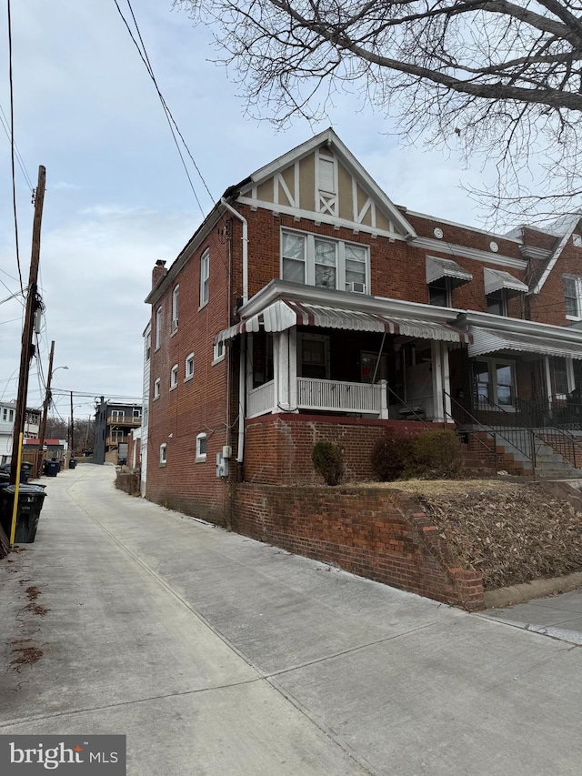 view of front of house with a porch and brick siding