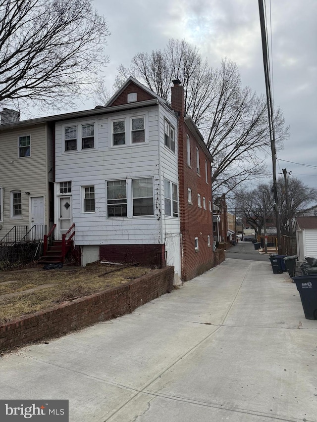 view of side of property featuring entry steps and a chimney