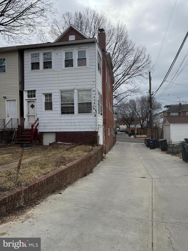 view of side of property featuring entry steps and a chimney