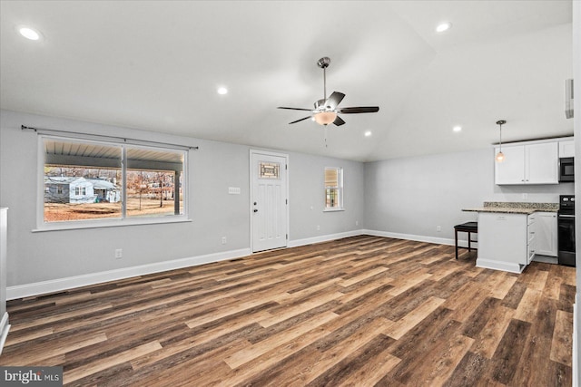 unfurnished living room with baseboards, vaulted ceiling, wood finished floors, and recessed lighting