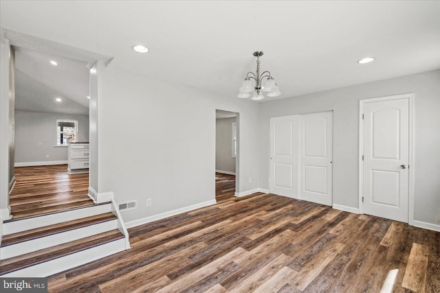 unfurnished dining area featuring recessed lighting, baseboards, an inviting chandelier, and wood finished floors