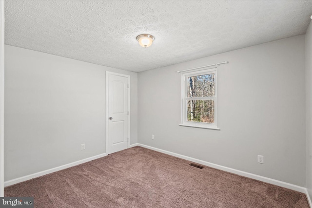 carpeted empty room with visible vents, baseboards, and a textured ceiling