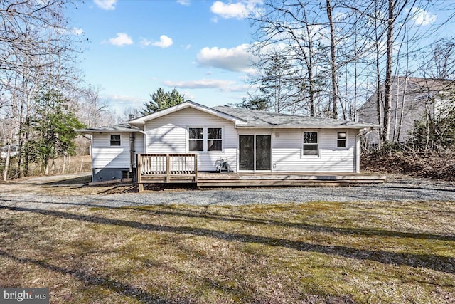 back of property with a lawn and a wooden deck