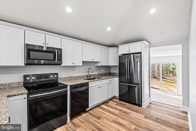 kitchen featuring light wood-style floors, appliances with stainless steel finishes, white cabinets, and a sink