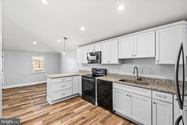 kitchen with light wood-style floors, a peninsula, black appliances, white cabinetry, and a sink