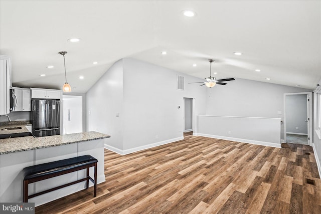 kitchen with stainless steel appliances, visible vents, white cabinetry, vaulted ceiling, and a sink