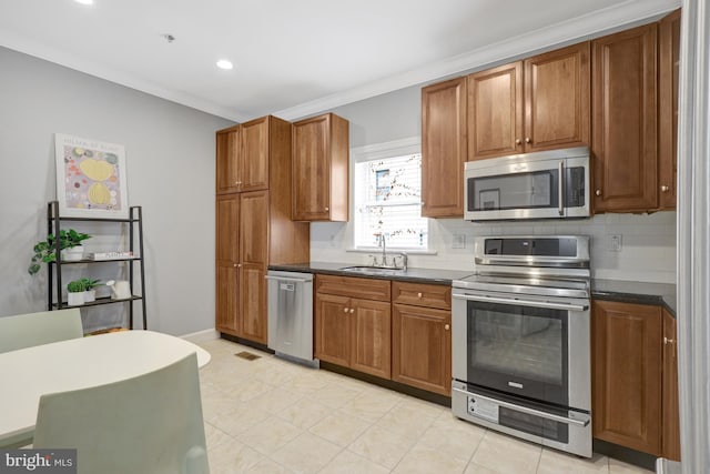 927 12th St NE, Washington, DC 20002 - kitchen with stainless steel appliances, a sink, brown cabinets, and dark countertops