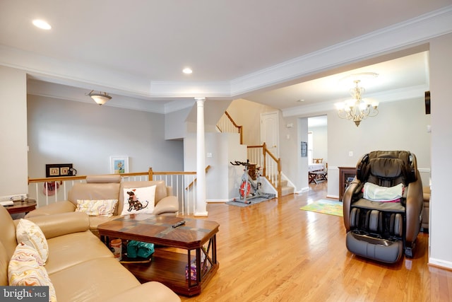 living room featuring light wood finished floors, baseboards, stairway, and crown molding