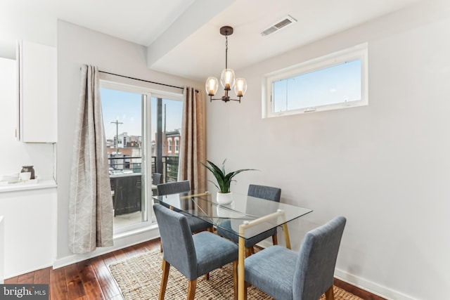 dining space with a chandelier, baseboards, visible vents, and hardwood / wood-style floors