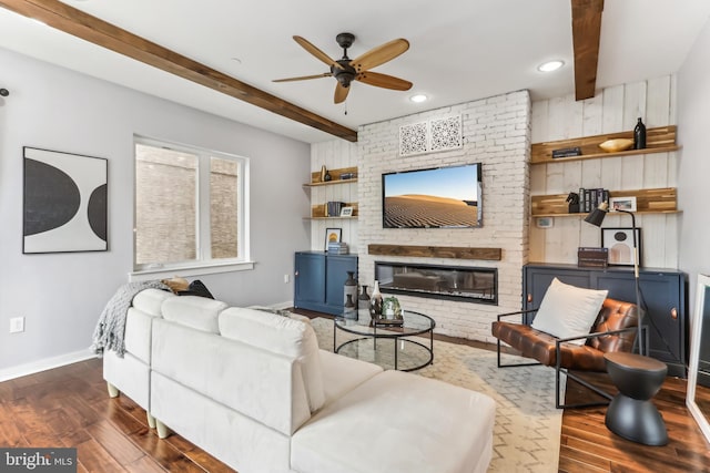 living room featuring beamed ceiling, a fireplace, wood finished floors, and baseboards