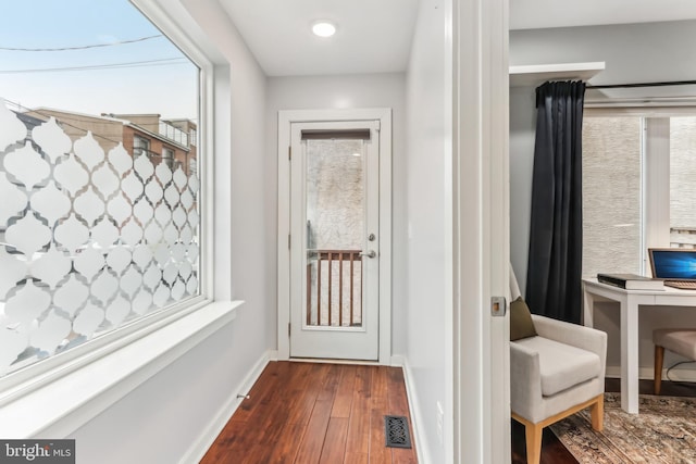 entryway featuring visible vents, baseboards, and wood finished floors