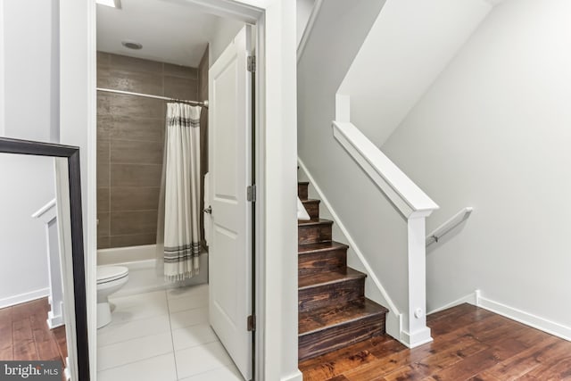 staircase with baseboards and wood finished floors