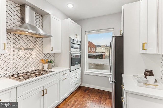 kitchen with white cabinets, wall chimney range hood, dark wood-style floors, and stainless steel appliances